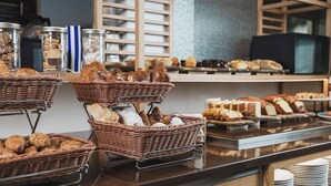 Un espositore di panetteria con diversi pani e dolci in cesti di vimini.