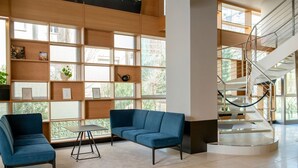 Un interno moderno con un divano blu, un tavolino e una scala.