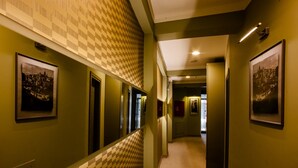 A hallway with patterned walls, framed pictures, and a carpeted floor. - Hotellino (Istanbul)