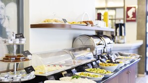 A buffet with various food items and a coffee machine. - Hotellino (Istanbul)