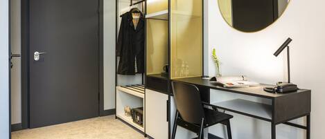 Un espacio de oficina moderno con escritorio, silla y un espejo grande.