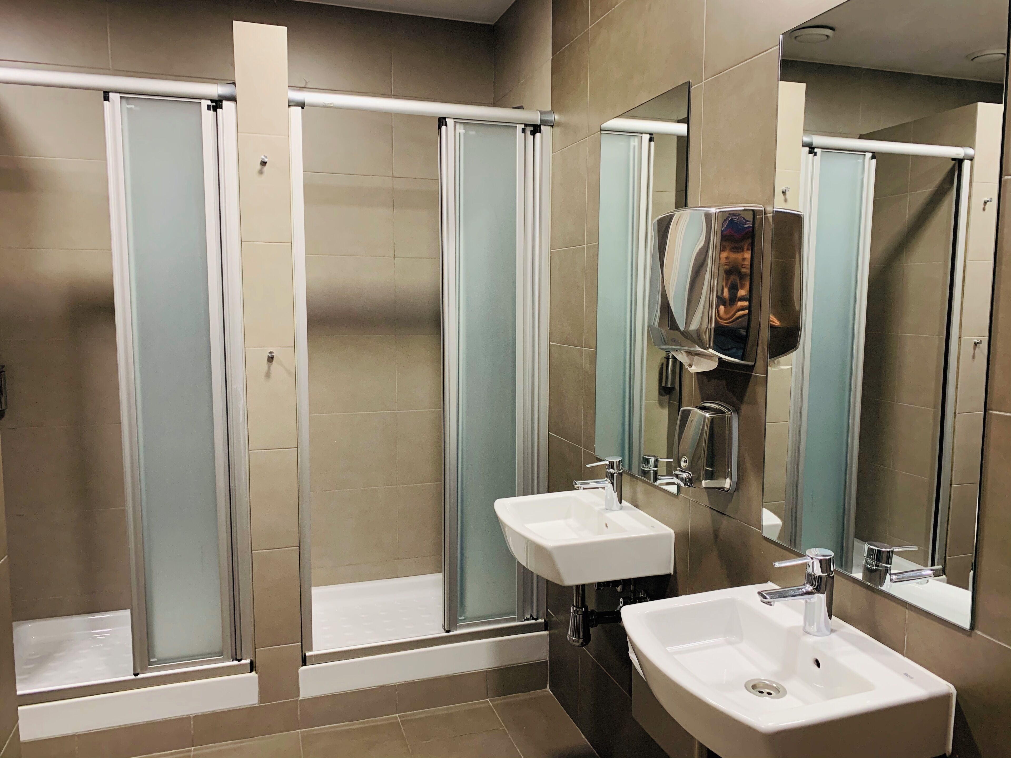 A modern bathroom with a glass-enclosed shower, a sink, and a mirror.