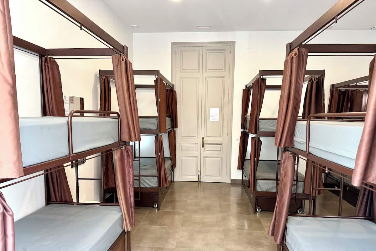 A room with bunk beds, a door, and a tiled floor.