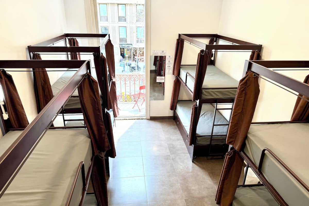 A corridor with bunk beds, a tiled floor, and a view of the street outside.