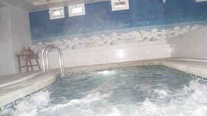 A hot tub with a tiled wall and a wooden bench. - Hermes (Tossa de Mar)