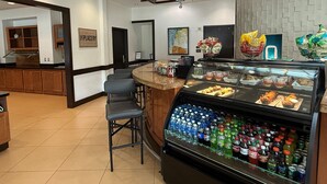 A bakery counter with pastries and a beverage display. - Hyatt Place Fort Myers/at The Forum (Fort Myers)