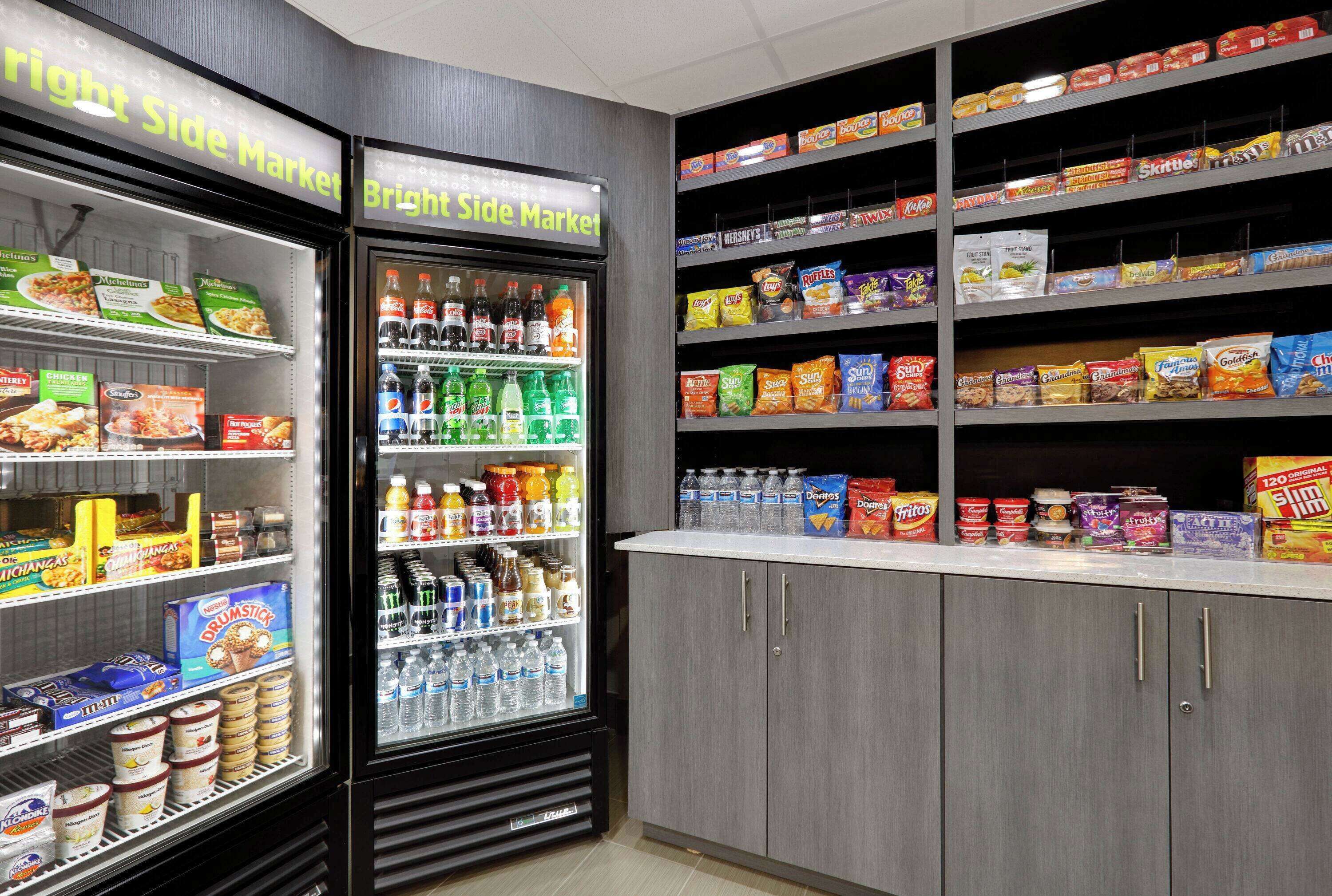 A grocery store with refrigerated sections and shelves stocked with snacks and beverages.