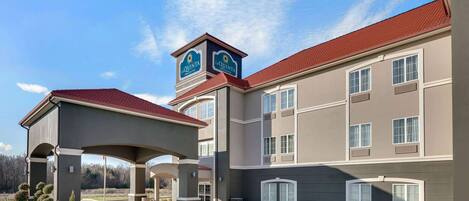 A hotel with a covered entrance, multiple windows, and a sign reading "La Quinta".