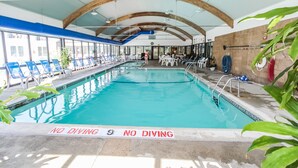 Una piscina interior con sillas azules y un letrero que dice 'NO DIVING'.