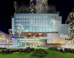 Experience the sleek, contemporary design of this hotel, featuring a glass facade and landscaped gardens with geometric patterns.