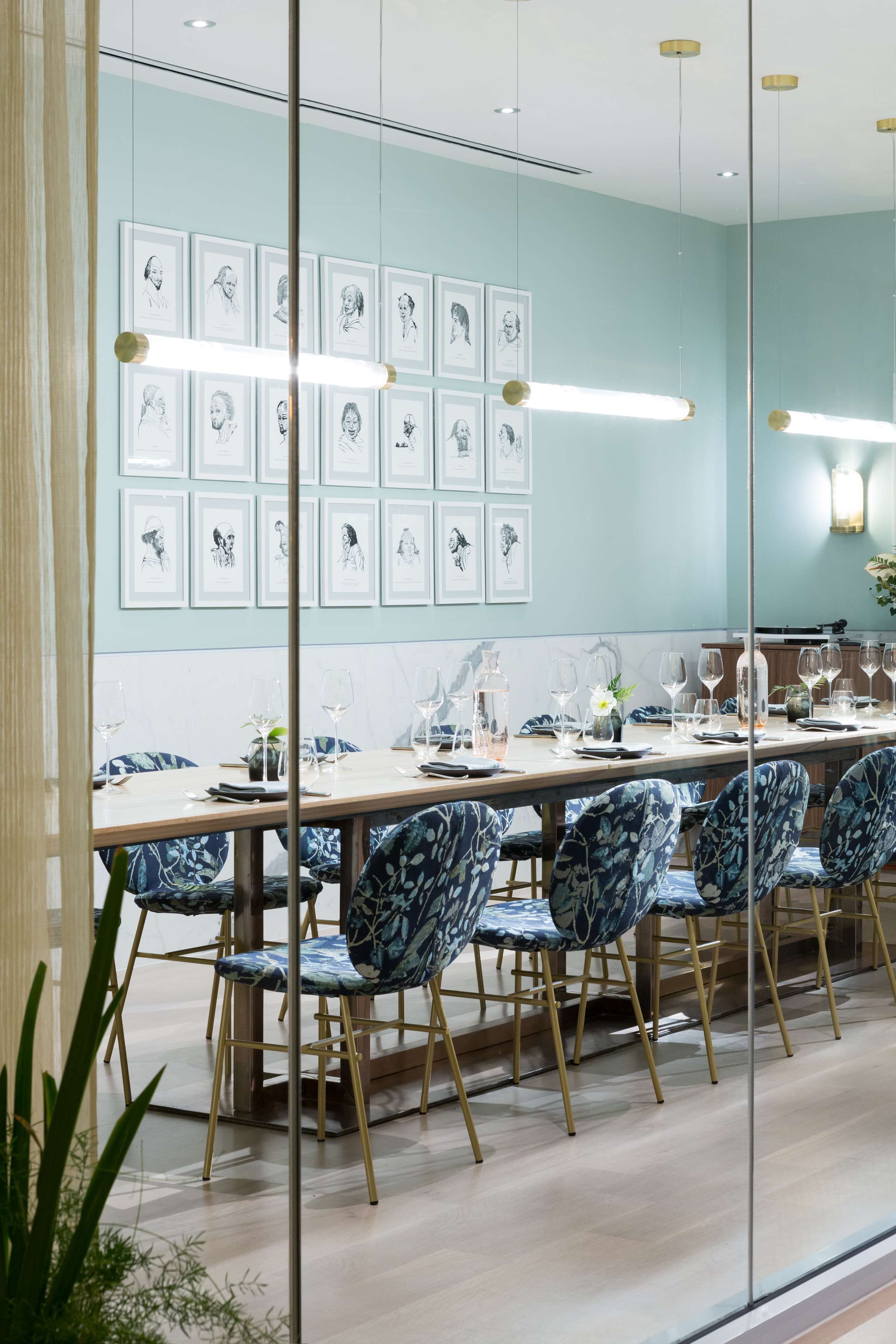 Comedor con una mesa larga dispuesta para seis personas, rodeada de sillas con estampado floral.