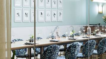 Comedor con una mesa larga dispuesta para seis personas, rodeada de sillas con estampado floral.