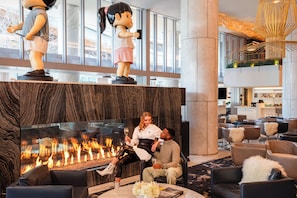 Relax in the inviting lobby, featuring a fireplace, comfortable seating, and a unique sculpture.