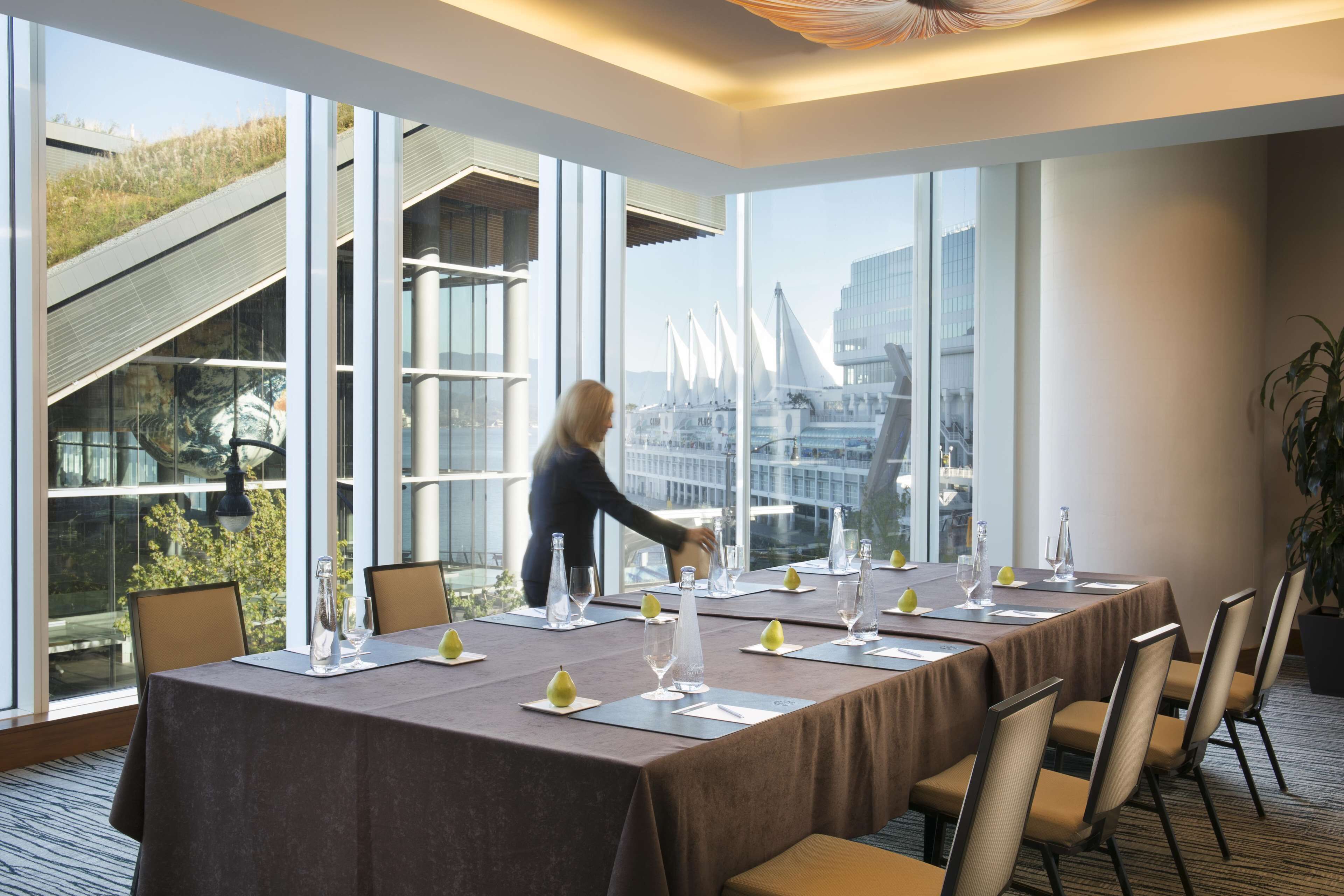 Una sala conferenze con un lungo tavolo, sedie e vista sulla città attraverso ampie finestre.