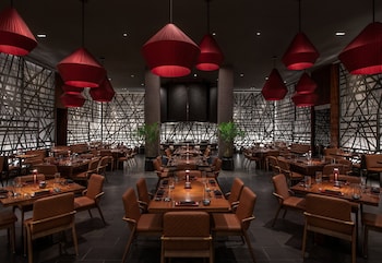 A modern lobby with a central cylindrical column covered in logs, a seating area with sofas, and a patterned floor. at The SKYLOFTS at MGM Grand