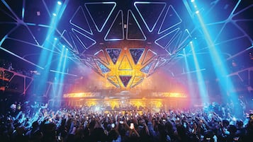 A concert with a large audience and stage lighting.