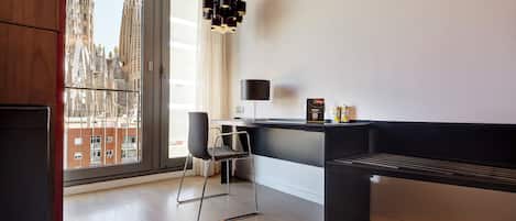 A modern room with a large window, a desk, a chair, and a black bench.