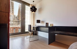 A modern room with a large window, a desk, a chair, and a black bench.