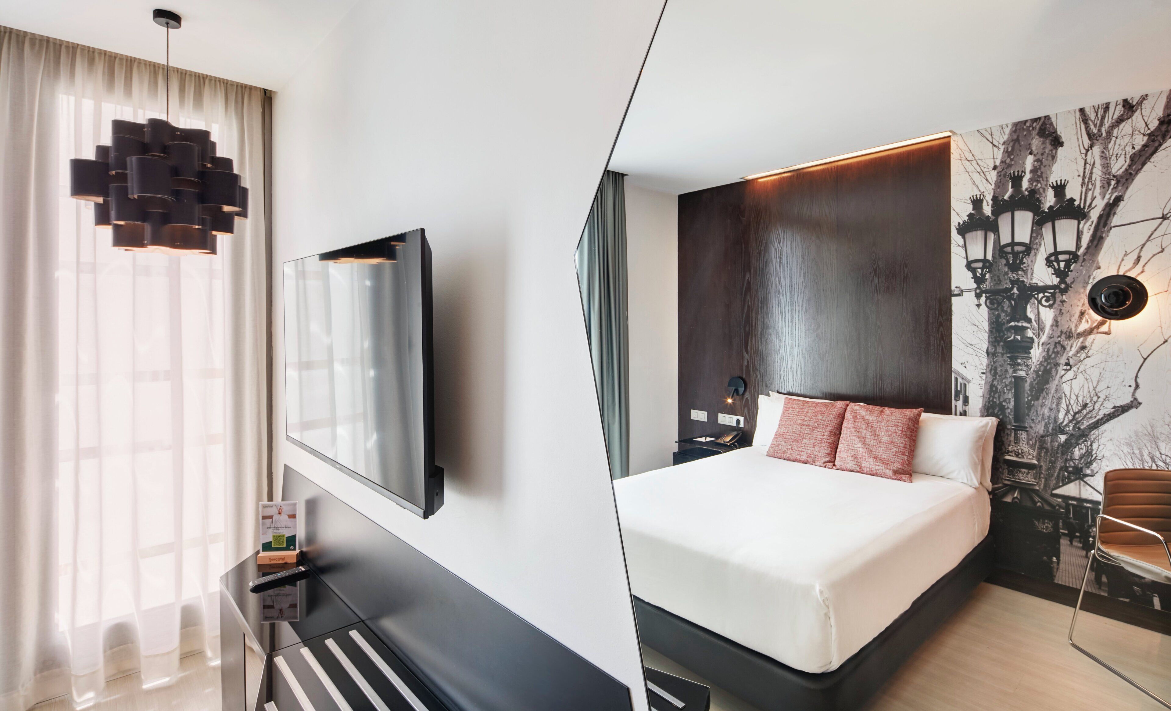 Una habitación de hotel moderna con una cama grande, un televisor montado, una lámpara colgante y una lámpara de pared.
