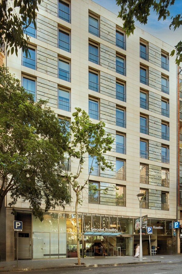 A multi-story hotel with a modern facade, large windows, and a visible entrance with a glass door. - Sercotel Rosellon (Barcelona)