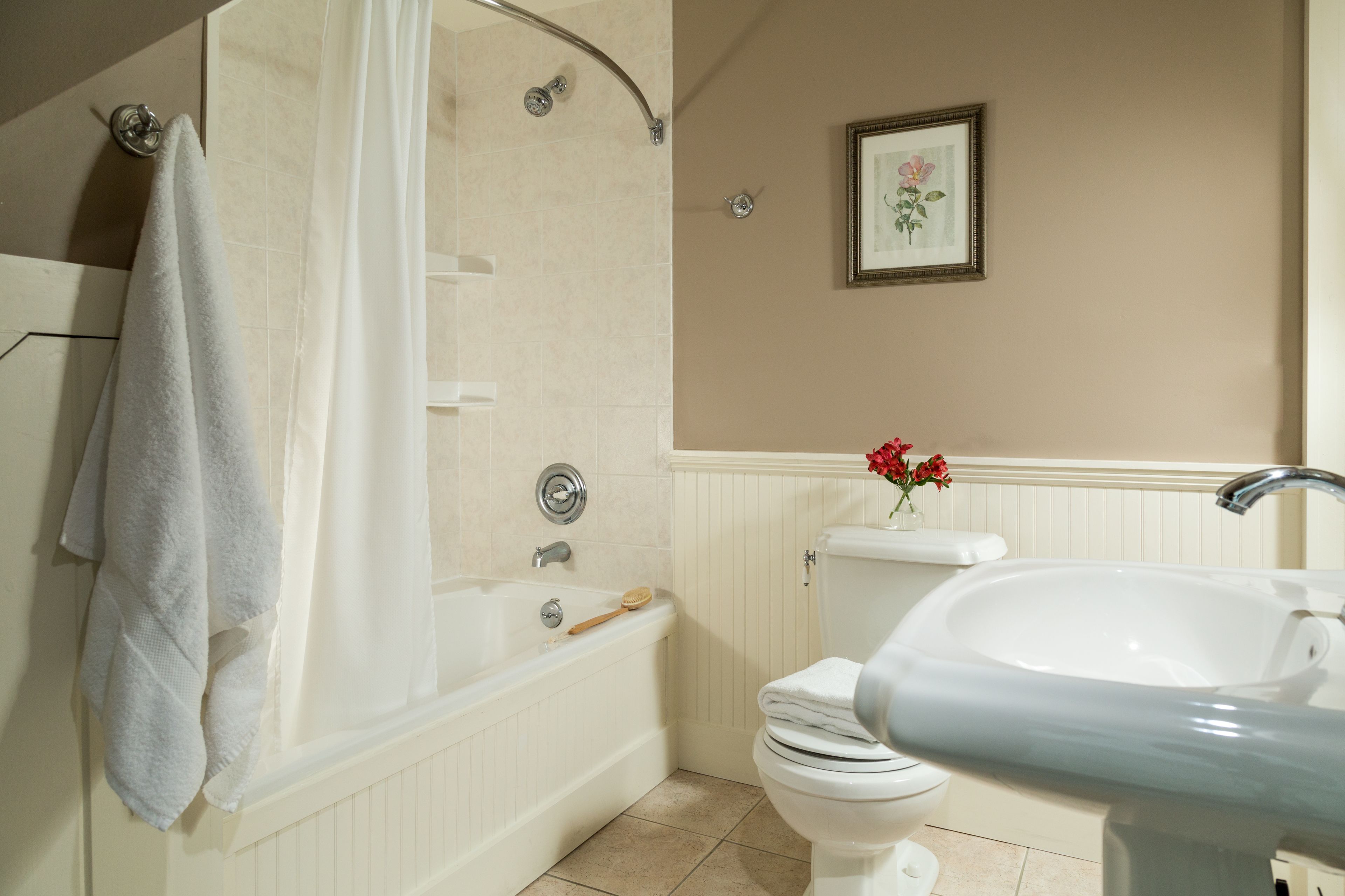 A bathroom with a bathtub, toilet, and sink.