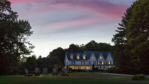 A large, multi-story house with a symmetrical roofline and multiple windows. - Inn at Pleasant Lake (New London)