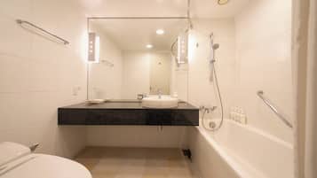 A modern bathroom with a toilet, sink, shower, and a mirror above the sink.