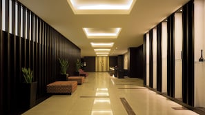 A hotel lobby with a long corridor, seating areas, reception desk, and modern lighting. - Holiday Inn Osaka Namba by IHG (Osaka)