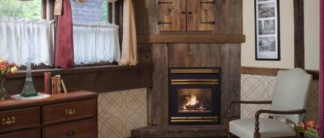 Una habitación acogedora con chimenea, muebles de madera y un cartel en la pared que dice 'PARIS'.
