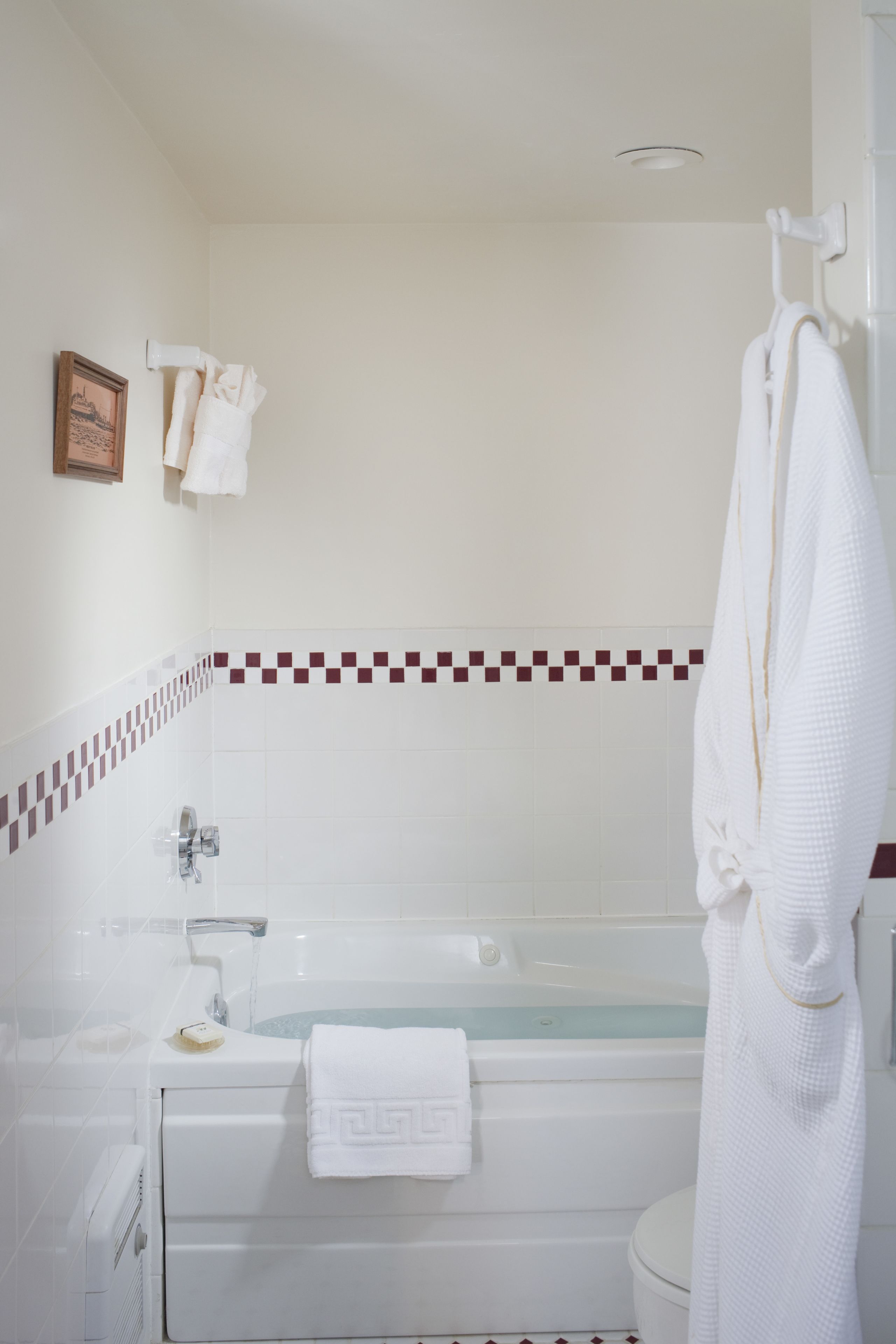 Ein Badezimmer mit Badewanne, Toilette und Handtuchhalter mit Handtüchern.