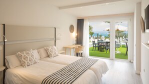 Una camera d'albergo con un letto grande, una scrivania e un balcone con mobili da esterno.