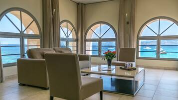 Suite Prestige vue sur la mer | Salle de séjour | Télévision LCD de 66 cm avec chaßnes par satellite, télévision, livres