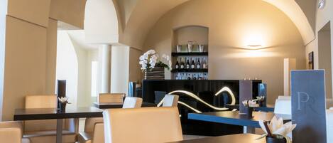 Una hall d'albergo moderna con area bar, posti a sedere e reception.