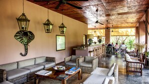 A spacious lounge area with wicker furniture, ceiling fans, and hanging lanterns. - Honeyguide Tented Safari Camps - Mantobeni (Bushbuckridge)
