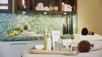 Een wellness omgeving met diverse Babor huidverzorgingsproducten, een massageborstel en handdoeken op een houten dienblad.
