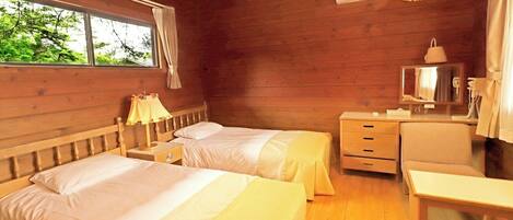 Habitación de cabaña de madera con dos camas, un escritorio, una silla, un espejo y una ventana con cortinas.