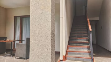 Una escala de fusta amb barana metàl·lica que condueix a un pis superior.