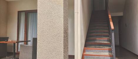 Una escalera con escalones de madera y barandillas de metal que conduce a un piso superior.