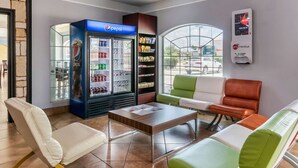 A lobby with seating, a Pepsi refrigerator, snack shelves, and a digital kiosk. - Quality Inn & Suites at The Outlets Mercedes/Weslaco (Mercedes)