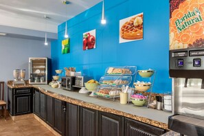 A breakfast bar with various food items and a beverage dispenser.