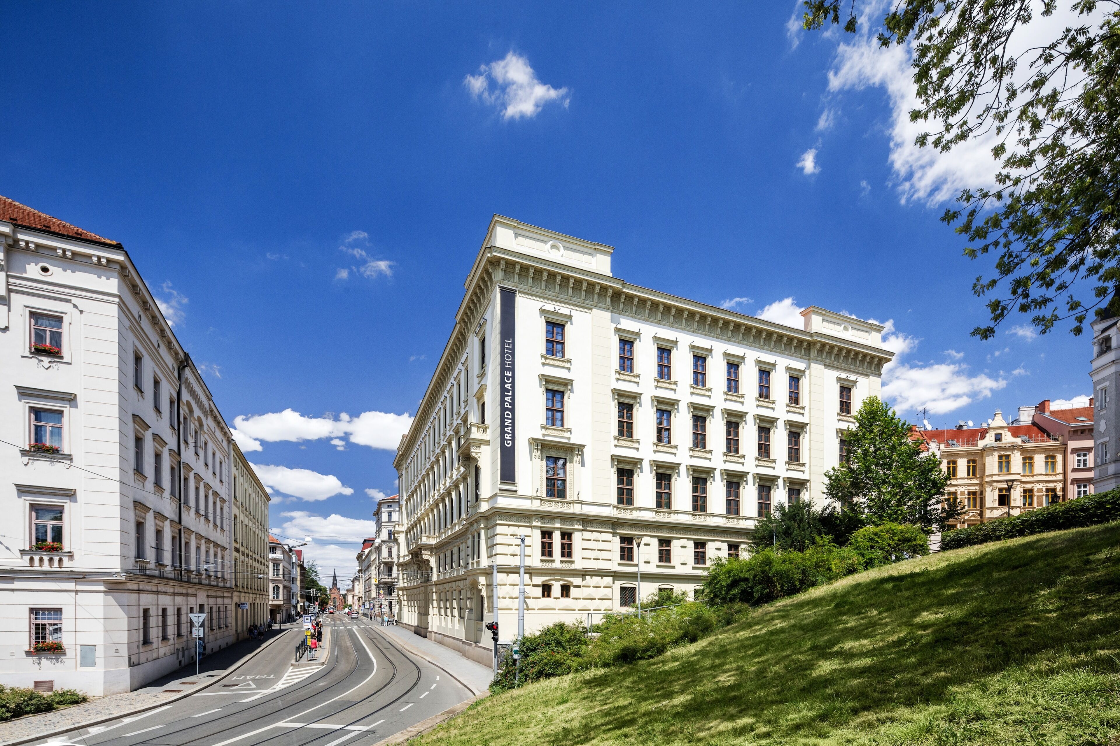 A grand hotel with classical architecture, a central entrance, and a street view.
