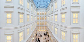 A grand atrium with multiple levels, large windows, and a glass ceiling. - Grand Palace Brno - Small Luxury Hotels of the World (Brno)