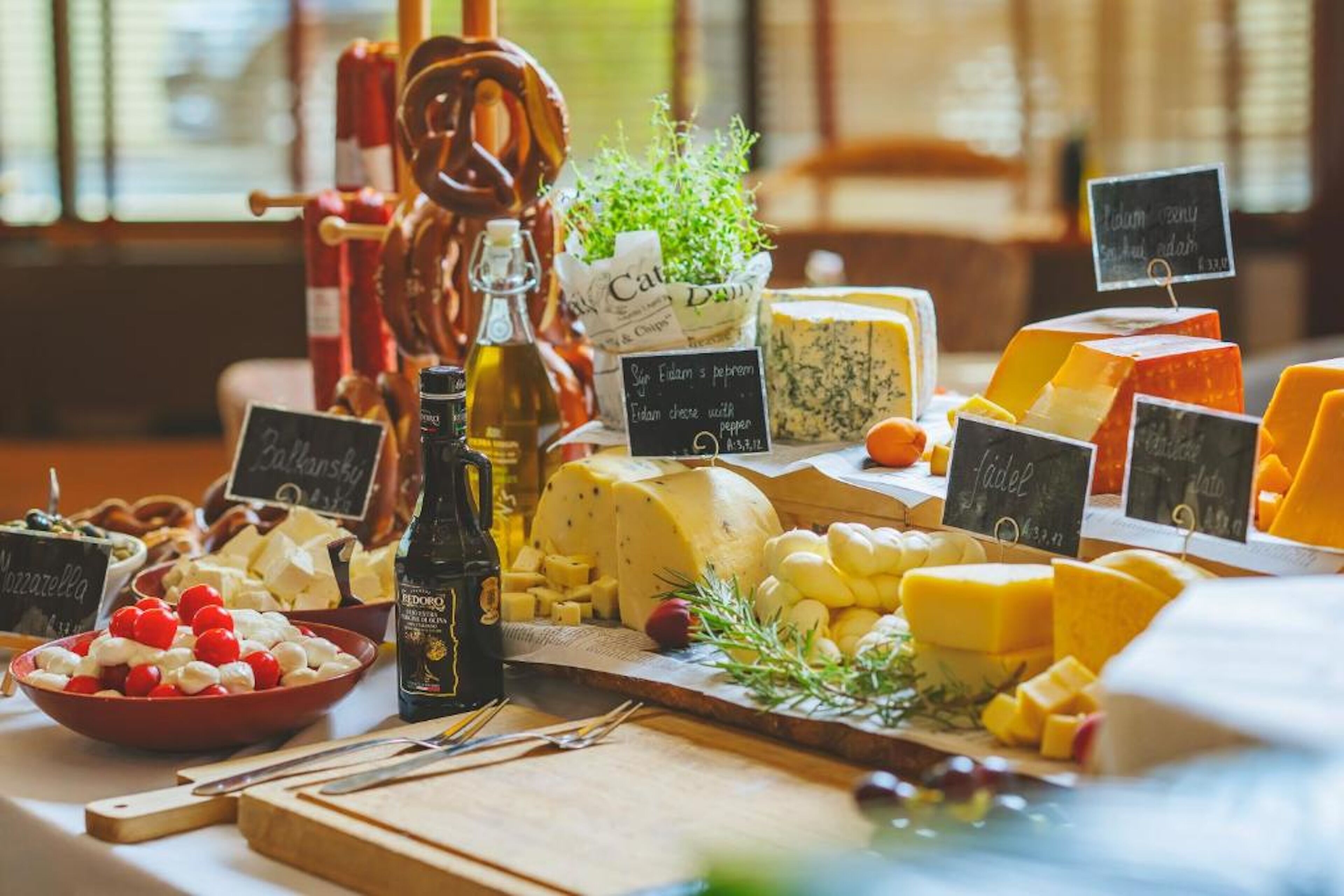 A cheese board with various types of cheese, crackers, and a bottle of wine.