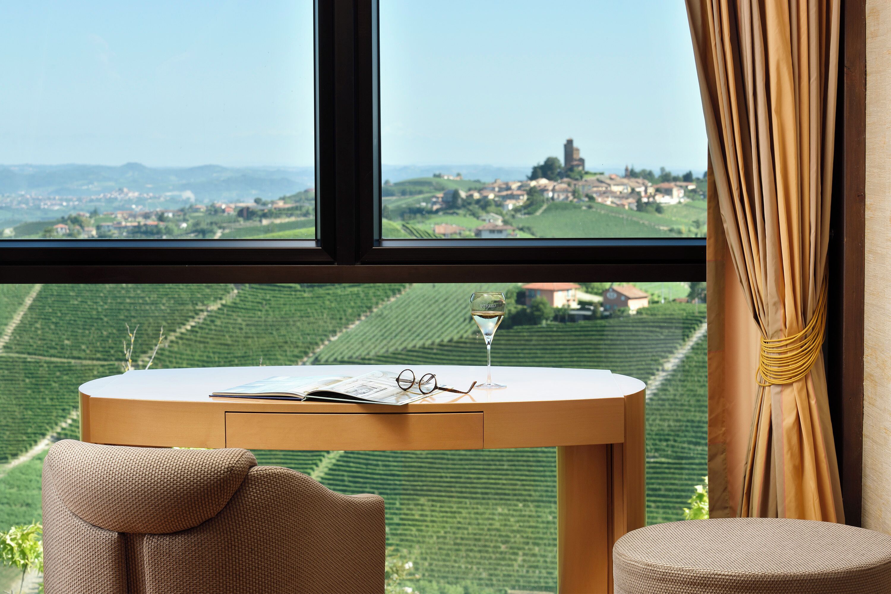 A room with a view of vineyards and a distant town.