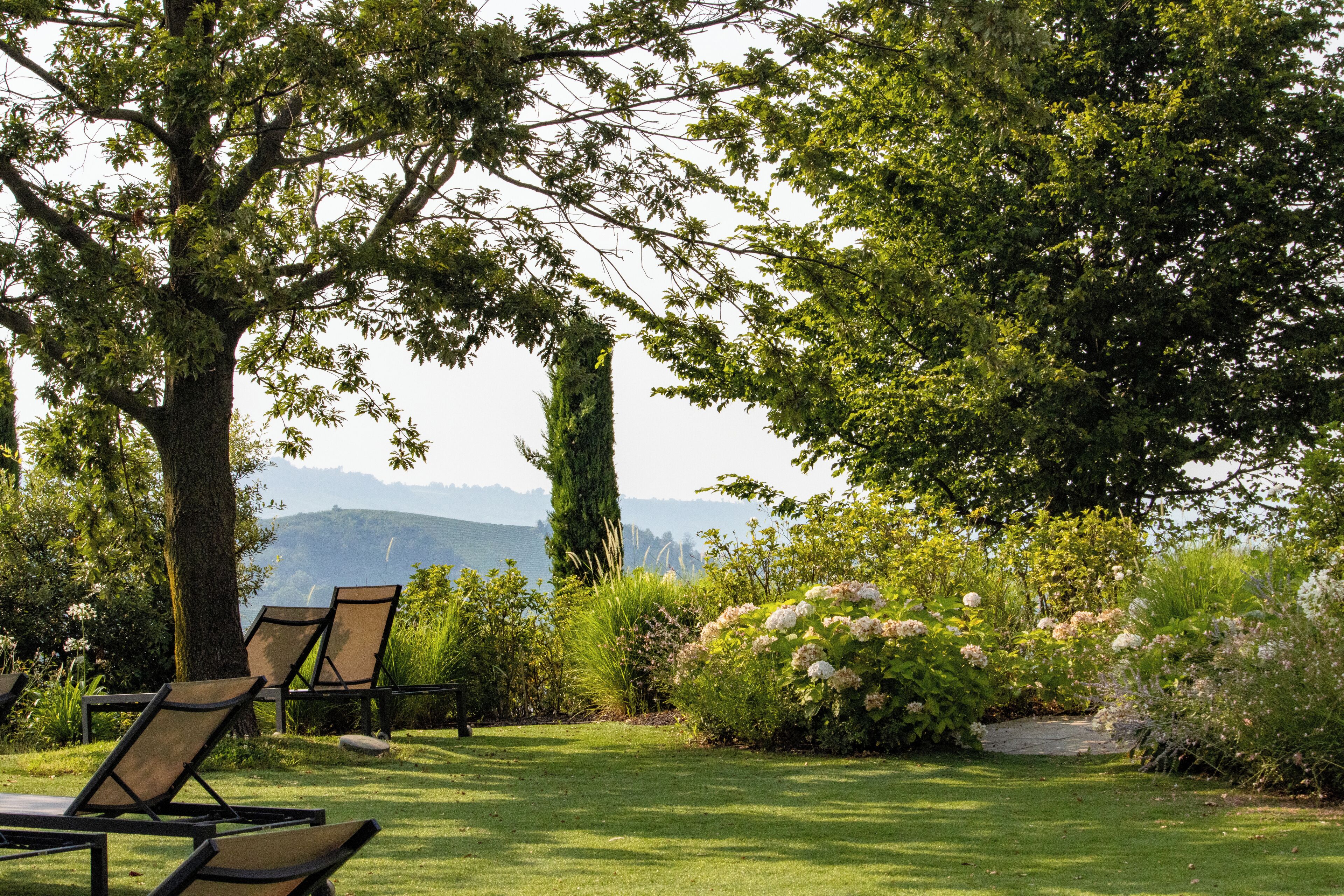 Un jardín con sillas y vistas a las montañas.