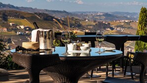 A dining table with a view of a mountainous landscape. - Il Boscareto Resort & Spa (Serralunga d'Alba)