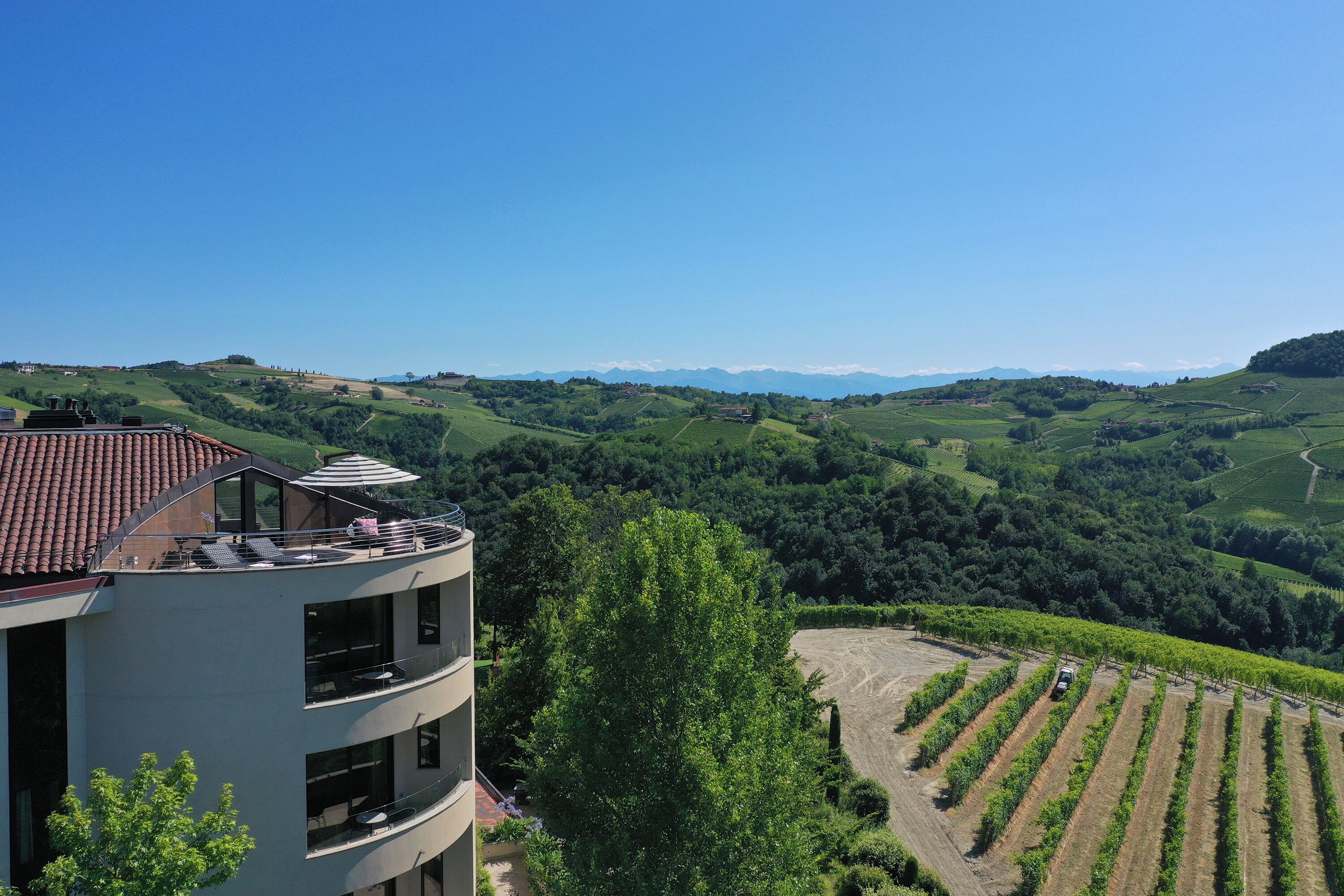 Ein mehrstöckiges Gebäude mit Balkonen mit Blick auf einen Weinberg.
