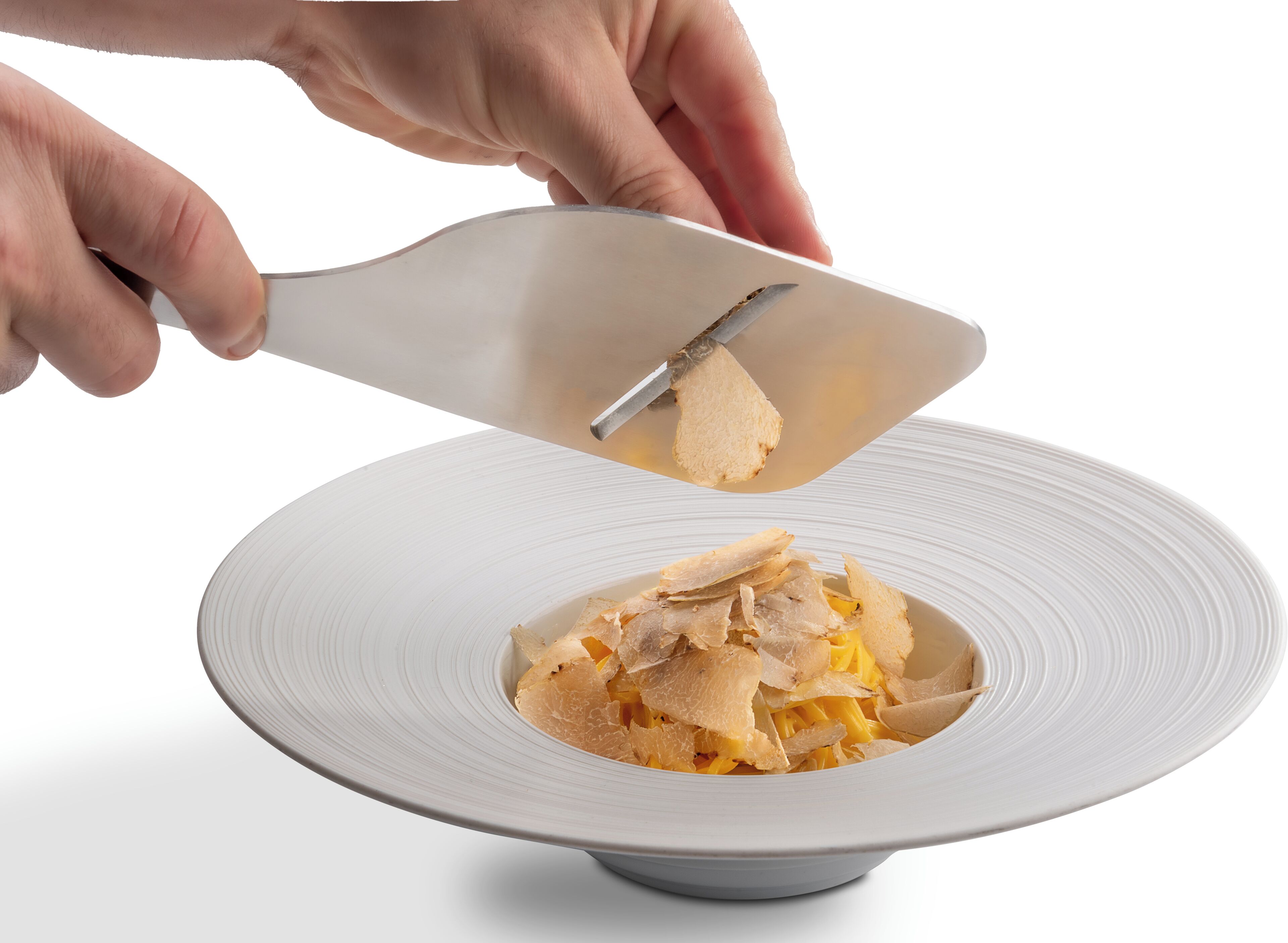 A hand using a spatula to serve food from a white plate.