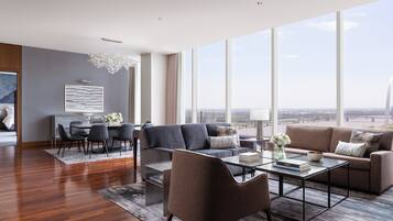 A spacious living room with a modern sofa, a coffee table, and a dining area with chairs and a table.