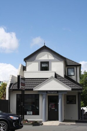 A two-story building with a reception area, a sign indicating 'No Entry', and a parked car in front. - Dunedin Motel and Villas (Dunedin)